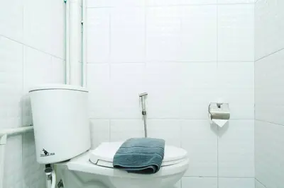 a bathroom with a toilet with a blue towel on it at 3BR Entire Home - Close to Train, Boat, IconSiam, Asiatique in Bangkok