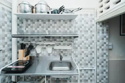 a kitchen with a sink and a shelf with pots and pans at 3BR Entire Home - Close to Train, Boat, IconSiam, Asiatique in Bangkok