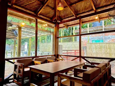 a wooden table and chairs in a room with a large window at Bruce House in Nonthaburi