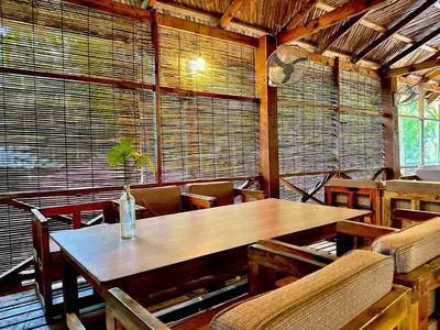 a dining room with a wooden table with a plant on it at Bruce House in Nonthaburi