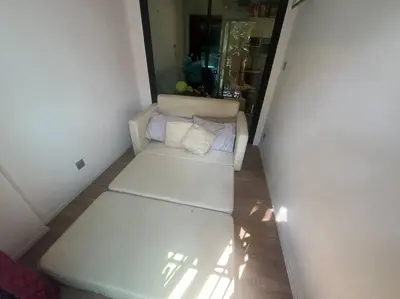 a small room with a white couch with pillows at Great Value Apartment in Bang Khen