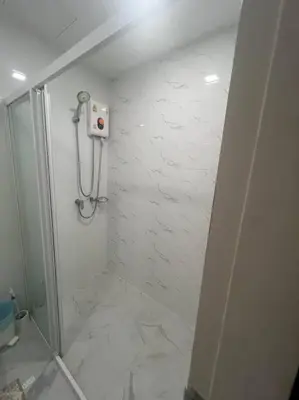 a bathroom with a shower with white marble tiles at Great Value Apartment in Bang Khen