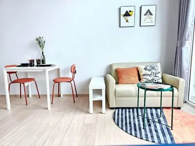 a living room with a couch and a table and chairs at Midtown Duplex Ratchayothin in Bangkok