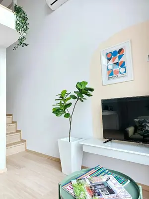 a living room with a table and a potted plant at Midtown Duplex Ratchayothin in Bangkok