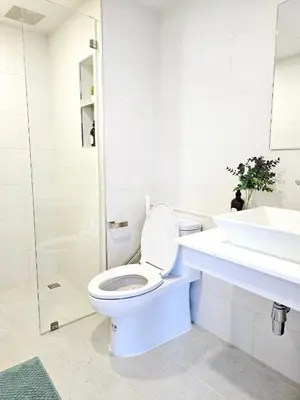 a white bathroom with a toilet and a sink at Midtown Duplex Ratchayothin in Bangkok