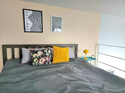 a bed with colorful pillows on it in a bedroom at Midtown Duplex Ratchayothin in Bangkok