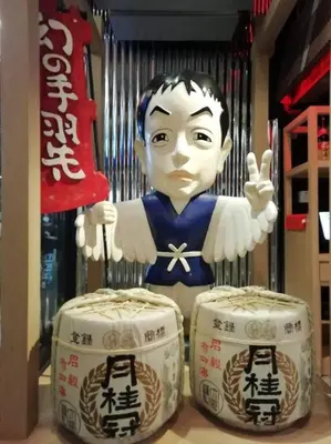 a statue of a man standing next to two drums at Cozy 1 Bedroom Apartment Close by Ratchada in Bangkok