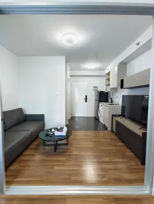 a living room with a couch and a table at Fully Furnished Apartment Close to MRT Pool n Gym in Nonthaburi