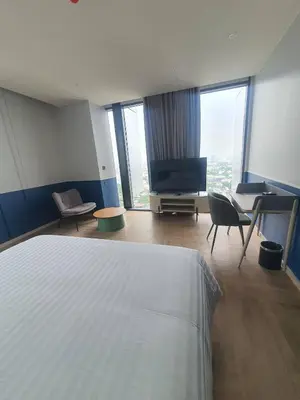 a bedroom with a bed and a flat screen tv at The Quarter Ramkhamhaeng by UHG in Bangkok