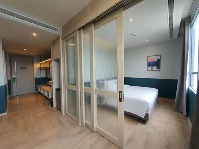 a bedroom with a bed and sliding glass doors at The Quarter Ramkhamhaeng by UHG in Bangkok