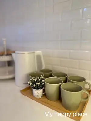 a group of cups on a wooden tray with a plant at My Happy Place in Nonthaburi