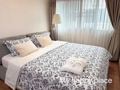 a bedroom with a bed with a blue and white bedspread at My Happy Place in Nonthaburi