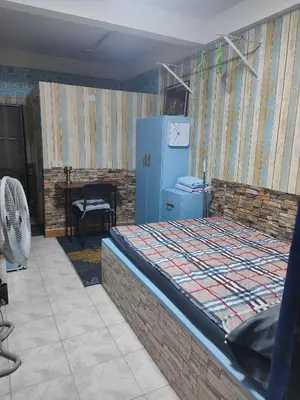 a room with a bed and a blue refrigerator at Jplace 101 Spacious Apartment with free Wi-fi in Bangkok