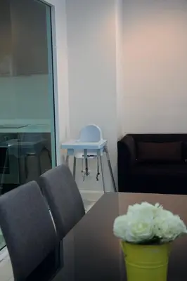 a table with two chairs and a vase of flowers on it at Entire Townhome 3BR3B, Pool, Sukhumvit-EmSphere in Bangkok