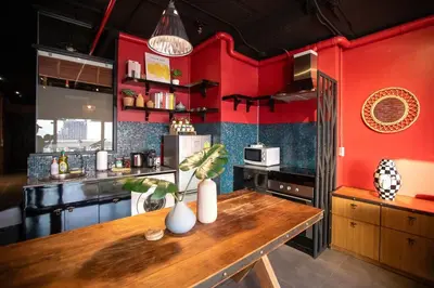 a kitchen with red walls and a wooden table at Best river view - Loft apartment in great location in Bangkok