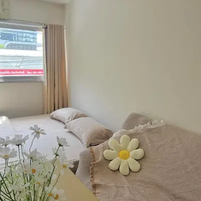 a bedroom with a bed with a flower on it at Happy Daisy ห้องพัก เมืองทองธานี in Nonthaburi