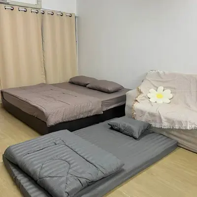 two beds sitting on the floor in a room at Happy Daisy ห้องพัก เมืองทองธานี in Nonthaburi