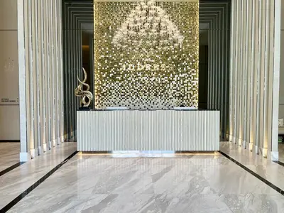 a lobby with a large wall with a chandelier at The Address Siam Luxury Two Bedrooms in Bangkok