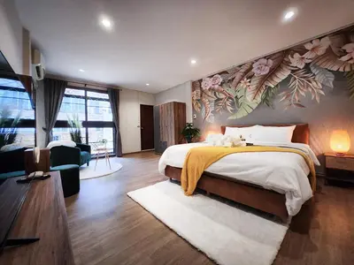 a bedroom with a large bed with a flower mural on the wall at Asokes Hidden Gem Cozy Stay Next to the Park in Bangkok