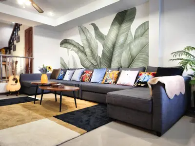 a living room with a blue couch with colorful pillows at Asokes Hidden Gem Cozy Stay Next to the Park in Bangkok