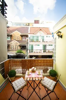 a patio with a table and chairs on a balcony at Asokes Hidden Gem Cozy Stay Next to the Park in Bangkok
