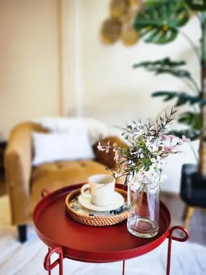 a red table with a cup of coffee and flowers on it at Asokes Hidden Gem Cozy Stay Next to the Park in Bangkok