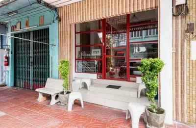 a store front with two chairs and a bench outside at 1137 Hostel in Bangkok