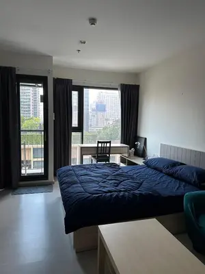 a bedroom with a blue bed and a desk and window at Thong Lor, Sukhumvit 36 in Bangkok