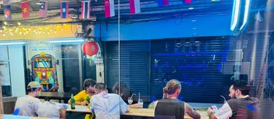 a group of people sitting at tables in a restaurant at The LODGE BKK Hostel in Bangkok