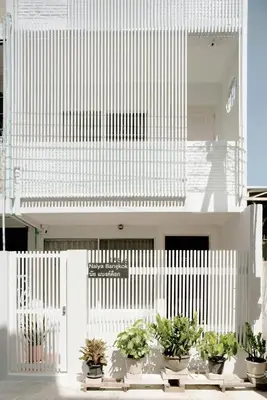 a white building with potted plants in front of it at Naiya Bangkok in Bangkok