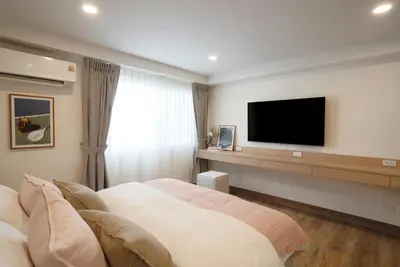 a hotel room with a bed and a flat screen tv at Naiya Bangkok in Bangkok