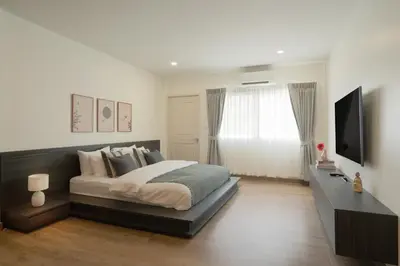 a bedroom with a bed and a flat screen tv at Naiya Bangkok in Bangkok