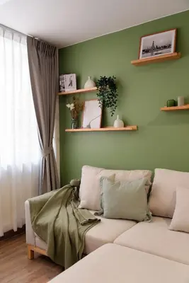 a living room with a couch and a green wall at Naiya Bangkok in Bangkok