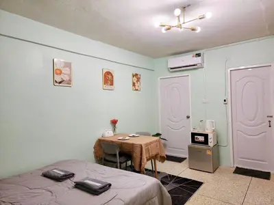 a room with two beds and a table with a tableablish at 811-STP Homely room Free Wi-Fi and Near BTS Line in Bangkok