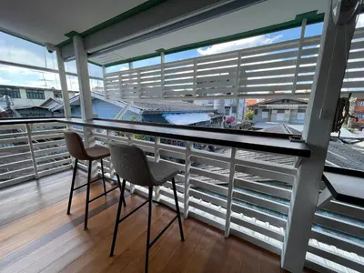 a balcony with two chairs and a table at Green Cabin Hostel in Bangkok