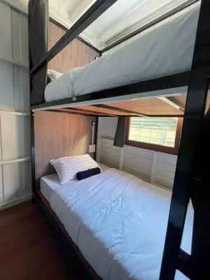 a bedroom with two bunk beds in a house at Green Cabin Hostel in Bangkok