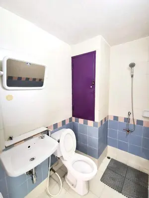 a bathroom with a toilet and a sink and a purple door at R Lodge in Bangkok