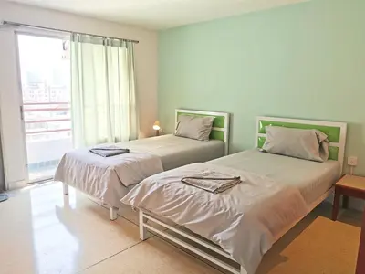 two beds in a room with a window at R Lodge in Bangkok