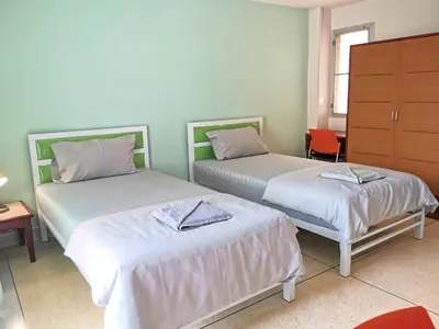 a bedroom with two beds and a dresser at R Lodge in Bangkok