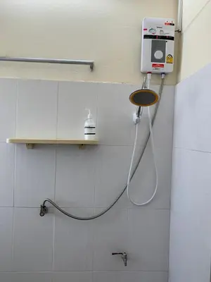 a shower in a bathroom with a hose on a wall at The House Hostel 2 in Bangkok