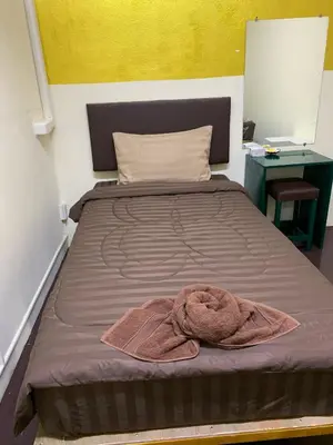 a bed with a blanket and a towel on it at The House Hostel 2 in Bangkok