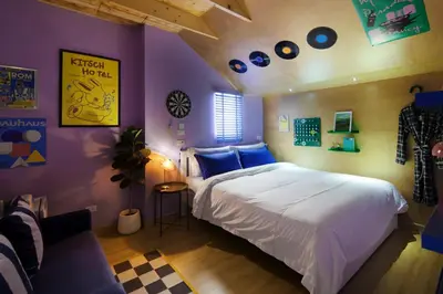 a bedroom with a large bed and purple walls at Kitsch Hotel in Bangkok