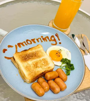 a breakfast plate with an egg and toast and potatoes at Charming Hostel in Bangkok