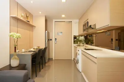 a kitchen with a counter and a dining room at Shine Aparthotels Sukhumvit Thonglor in Bangkok