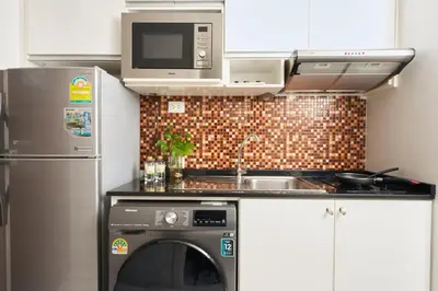 a kitchen with a microwave and a dishwasher at Shine Aparthotels Sukhumvit Thonglor in Bangkok