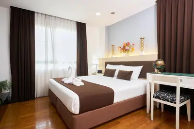 a bedroom with a bed and a desk and a window at Shine Aparthotels Sukhumvit Thonglor in Bangkok
