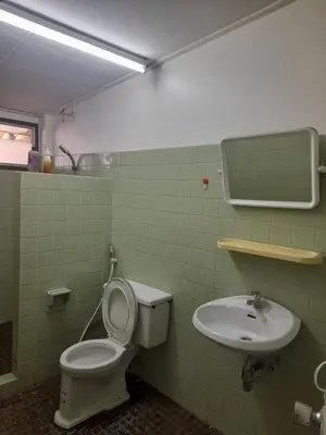 a bathroom with a toilet and a sink at Sirin Home in Bangkok