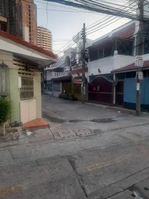 an empty street in a city with buildings at Sirin Home in Bangkok