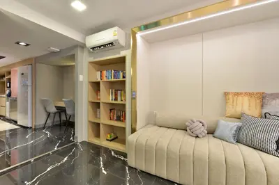 a living room with a couch and a book shelf at Victora Hostel in Bangkok