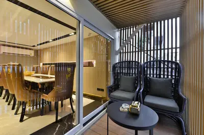 a balcony with chairs and a table and a dining room at Victora Hostel in Bangkok